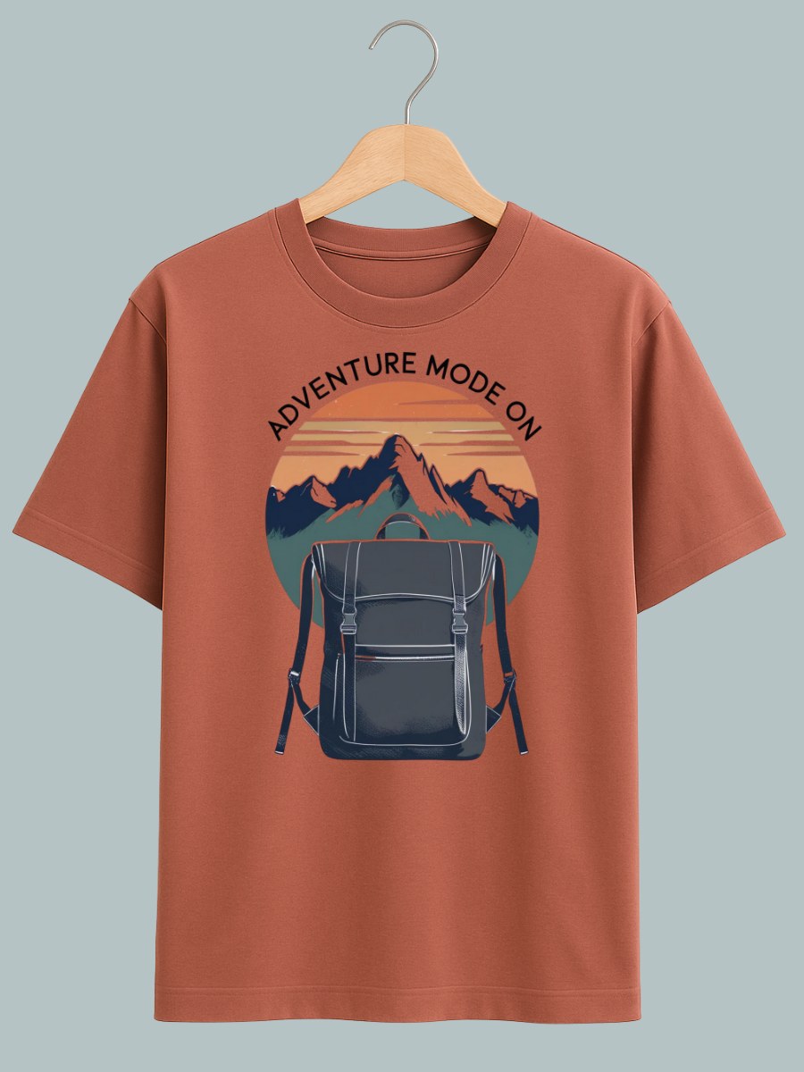Oversized travel T-shirt with ‘Adventure Mode On’ graphic featuring backpack design, perfect for explorers and streetwear fashion.
