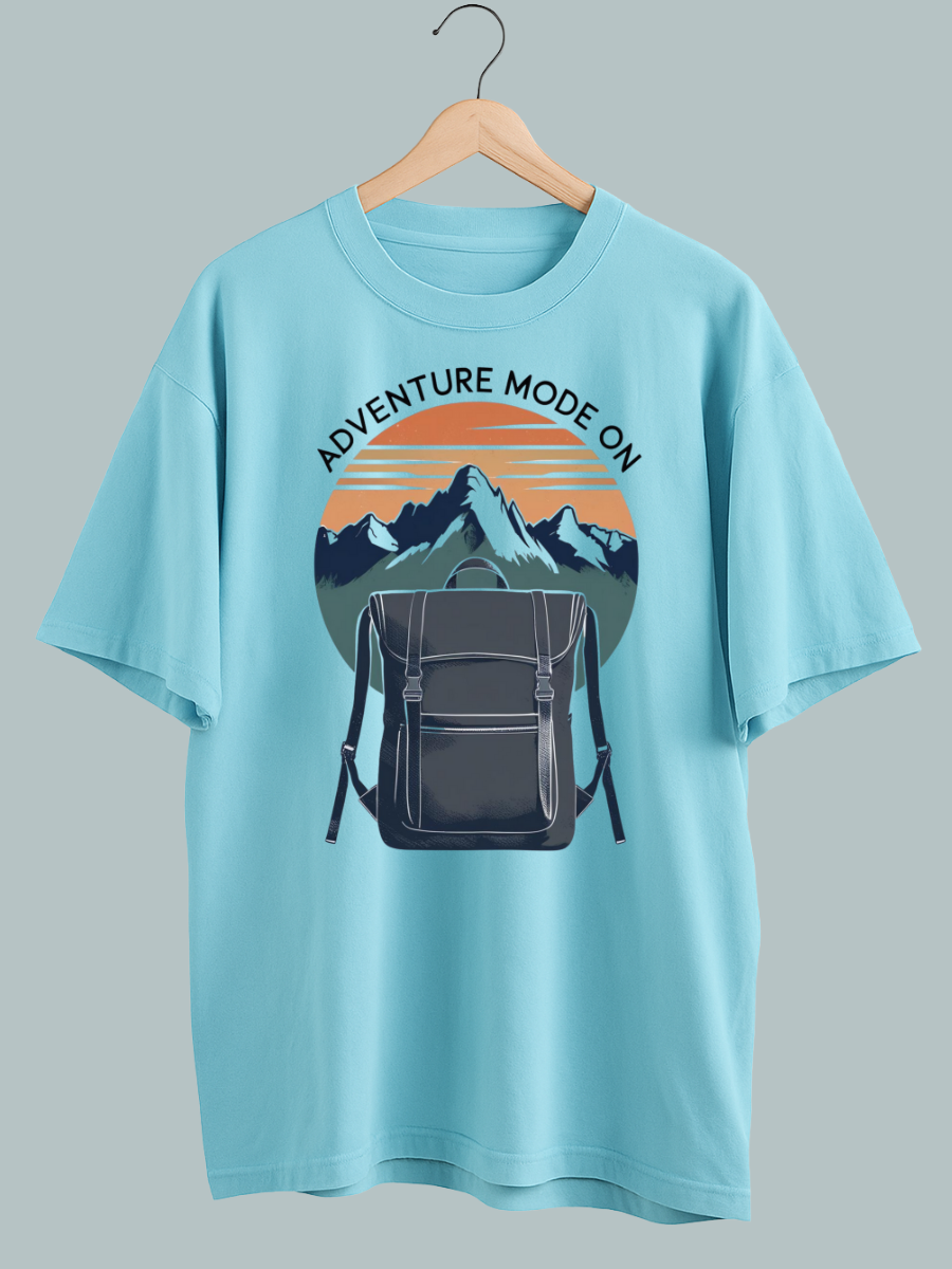 Oversized travel T-shirt with ‘Adventure Mode On’ graphic featuring backpack design, perfect for explorers and streetwear fashion.